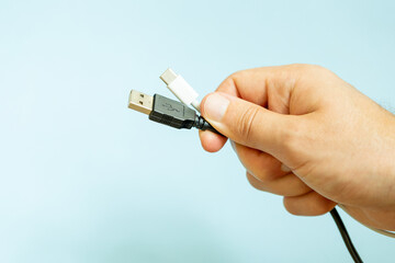 man holding several cables in hand, different types of USB cables, technology and connection  concept