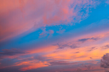 A breathtaking aerial view capturing a vibrant sunset over the Phuket countryside. The sky is ablaze with rich hues of yellow, orange, pink, and purple, while dramatic clouds float above the city