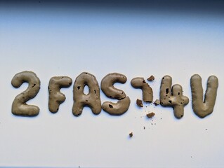 Zu schnell für dich - Buchstaben und Zahlen aus Keks. Ein Buchstabe wurde bereits eilig angeknabbert