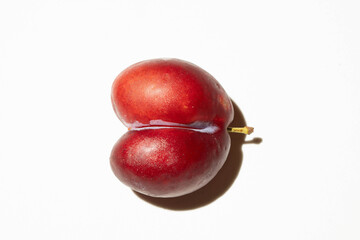 Heart-shaped fruit uncommon because it is two specimens joined by the same stem on a white background with shadow