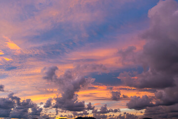 .The sky is painted with hues of deep orange, red, and pink, gradually blending into shades of purple and blue. The clouds reflect these vibrant colors, creating a breathtaking and serene landscape.