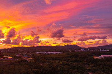 .The sky is painted with hues of deep orange, red, and pink, gradually blending into shades of purple and blue. The clouds reflect these vibrant colors, creating a breathtaking and serene landscape.