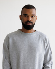 Portrait of young african american man in sweatshirt looking at camera isolated on grey