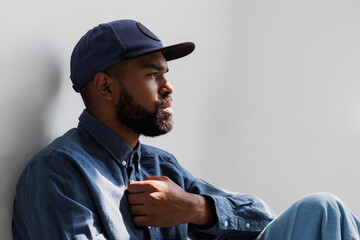 Portrait of african american man in casual shirt and snapback on grey background