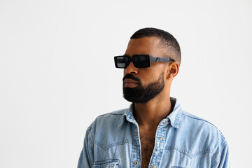 Bearded african american man in sunglasses and denim shirt isolated on grey