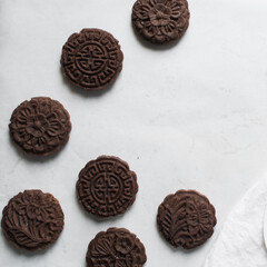 Overhead view of stamped chocolate cookies on a parchment lined baking tray, top view of embossed chocolate sugar cookies on a white background