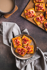 Delicious crackers baked with cheese and sausage on a plate and board top and vertical view