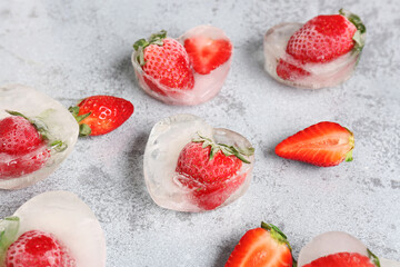 Fresh strawberry frozen in ice on grunge background