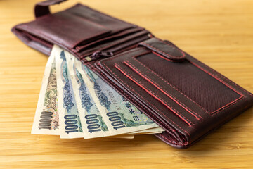 Japan money. Brown wallet with banknotes sticking out. Financial concept. Japanese yen