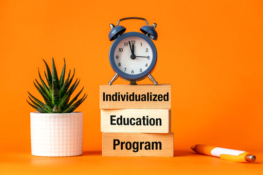 Individualized Education Program. IEP symbol. Program that provides specialized instruction and related services to a child with a diagnosed disability. Orange background, Words on wooden blocks