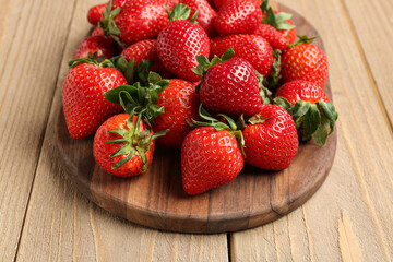 Board of fresh strawberries on wooden background