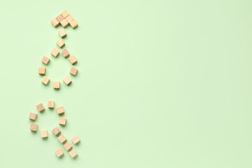 Male and female symbols made of wooden cubes on pale green background