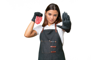 Butcher woman wearing an apron and serving fresh cut meat isolated on green chroma background making stop gesture
