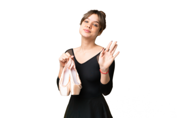 Young girl practicing ballet over isolated chroma key background saluting with hand with happy expression
