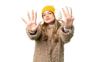 Young girl wearing winter muffs over isolated chroma key background counting nine with fingers