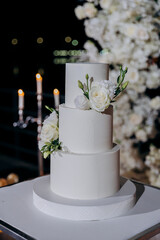 Wedding setup with three-tier white cake with floral accents. Wedding inspiration, luxury events