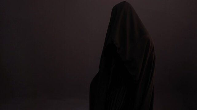 A mysterious silhouette in black, the wind blows the veil off the woman's face