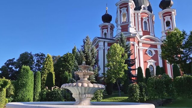 Curchi Monastery with the outdoor view in front of the fountain. Christian Orthodox church with a beautiful green garden located in Orhei, Moldova, Europe