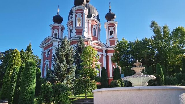 Curchi Monastery with the outdoor view in front of the fountain. Christian Orthodox church with a beautiful green garden located in Orhei, Moldova, Europe