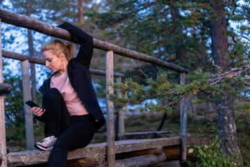 Fototapeta premium blonde woman hiking in the forest in Rovaniemi Finland Lapland, on a white night in summer with sunset