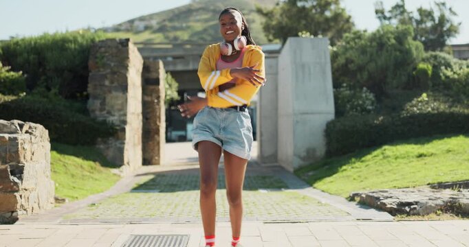 Dance, energy and a black woman walking in a park during summer for freedom or movement in rhythm. Portrait, smile or headphones with a happy young person moving to music in a garden to relax