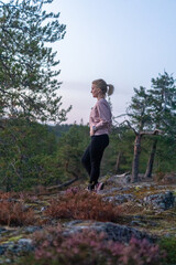 blonde woman hiking in the forest in Rovaniemi Finland Lapland, on a white night in summer with sunset