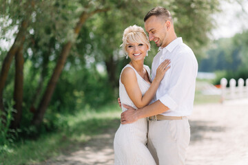 Fototapeta premium Happy Bride and Groom Embracing Outdoors on Their Wedding Day