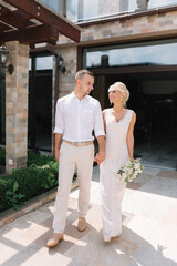 Smiling Bride And Groom Holding Hands In Sunny Outdoor Wedding Venue