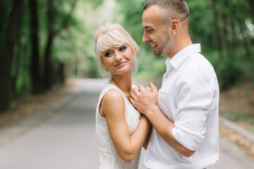 Obraz premium Romantic Couple Embracing in Forest Setting During Daylight, Capturing Love and Affection