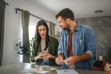 Couple learn and practice how to make a clay figurine, pottery