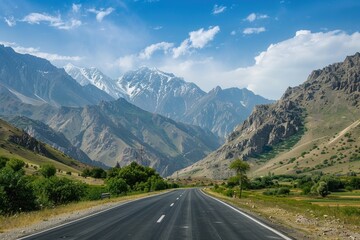Fototapeta premium A scenic highway winding through mountains with lush greenery and blue skies
