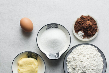 Overhead view of ingredients for making chocolate cookies, top view of mise en place of ingredients for making chocolate sugar cookies, process of making chocolate cookies