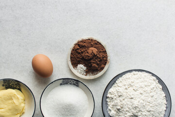 Overhead view of ingredients for making chocolate cookies, top view of mise en place of ingredients for making chocolate sugar cookies, process of making chocolate cookies
