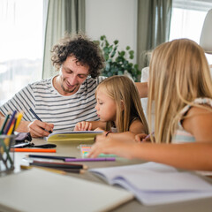 Single father write homework and study with his daughters