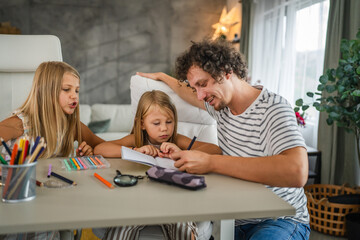Single father write homework and study with his daughters
