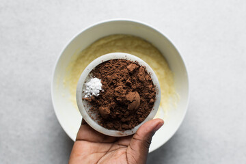 Cocoa powder in a white ceramic plate, clumpy cocoa powder into a small white plate