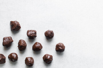 Overhead view of chocolate cookies dough on a parchment lined baking tray, top view of chocolate sugar cookie dough on a white background