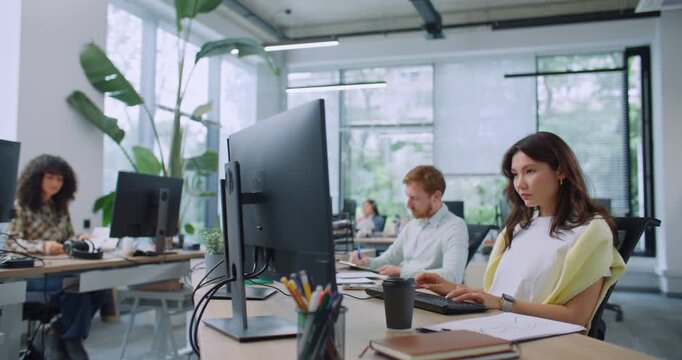 Group of hardworking multi-ethnic specialists using corporate computers. Professional managers working at modern office. Entering text on keyboards in electronic document management systems.