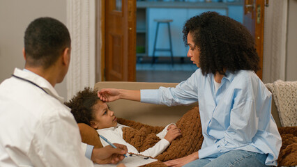 African American mother sitting sofa daughter parent childcare worries doctor visit home fever touching forehead high temperature flu virus epidemic illness unwell child kid sick unhealthy medicine