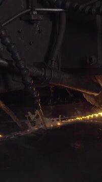 Welder complete with personal protective equipment is perform pipe welding in dark area using Automatic Welding System. Welding sparks spreading everywhere. Automat welding pipe production