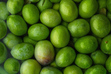 A pile of fresh green olives in close-up,texture of green olives background.