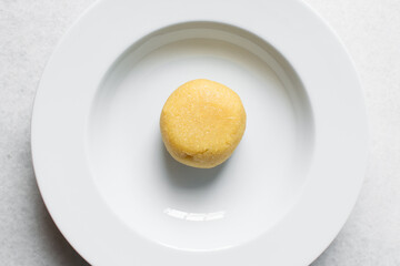 overhead view of Eba on a white plate, Nigerian garri, top view of yellow garri on a white plate