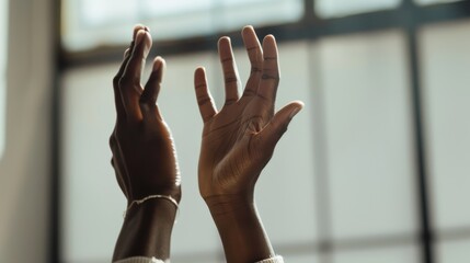 Woman with open hands reaching towards the light streaming in from a nearby window