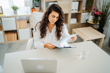 Young caucasian business woman working in office on laptop