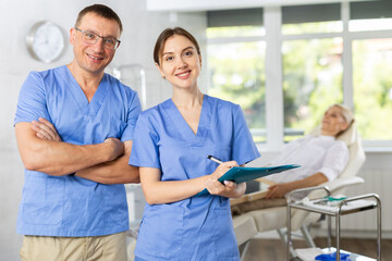 Obraz premium Portrait of two doctors - man and woman in the interior of the clinic