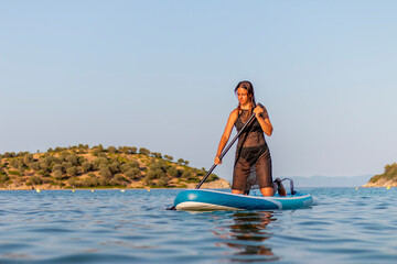 young woman with sup board in the sea