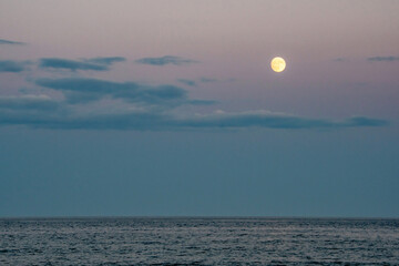 Full moon rises over the Atlantic ocean