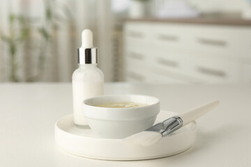Peeling procedure. Bottle of chemical peel, bowl with liquid and brush on white table indoors