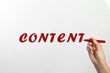 Word Content written by woman on glass against white background