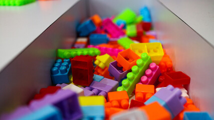 A close-up shot of colorful plastic building blocks arranged in a container, highlighting their...